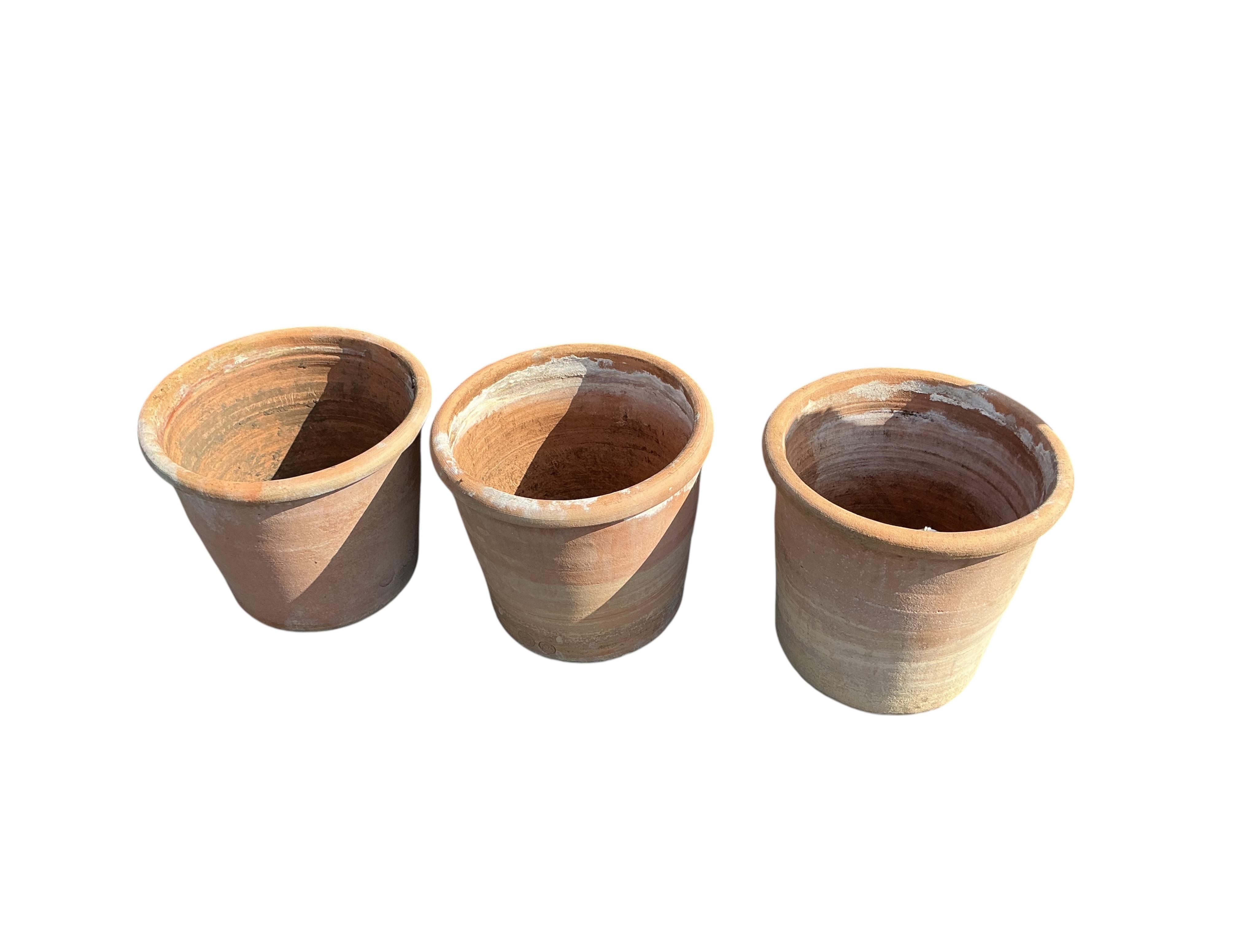 A set of three circular terracotta garden planters, diameter 41cm, height 38cm